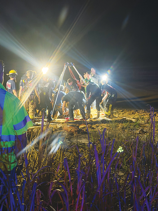 Rescue workers from numerous agencies work to dig out Jacksonville resident Andrew Giddens from quicksand at a Melrose borrow pit Wednesday night. (Photo submitted by Allison Waters-Merritt)